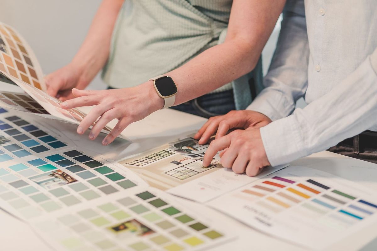 Deux personnes examinent des échantillons de couleurs et des plans d'architecture